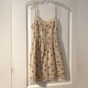 Cream spaghetti strap dress with small yellow floral print and lace trim
